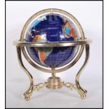 A vintage style lapis lazuli desk top globe having brass mounts with inset semi precious stones.