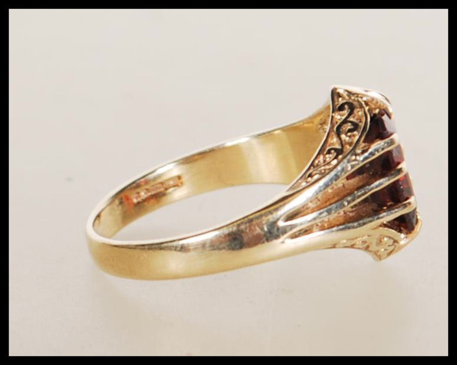 A hallmarked 9ct gold ring claw set with a rectangular cut red stone with reeded shoulders. - Bild 2 aus 5