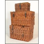 A group of three  20th century graduating wicker laundry / storage wicker baskets having hinged lids