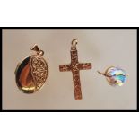 A group of three hallmarked 9ct gold pendants to include a locket of oval form with celtic knot