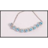 A stamped 925 silver bracelet set with round cut topaz and white accent stones having an