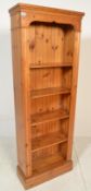 An antique style country pine upright bookcase cabinet. Raised on a plinth base with central bank of