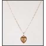 A 9ct gold heart shaped pendant having engraved swirl and foliate decoration to front and verso.