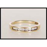 A hallmarked 9ct gold half eternity ring having suspension set diamonds in a channel setting.