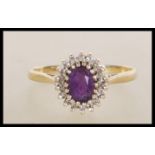 A hallmarked 9ct gold ring set with an oval cut purple stone with a halo of white accent stones.