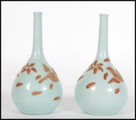 A pair of 19th Century Japanese slip decorated celadon stem vases being onion shaped. Each decorated