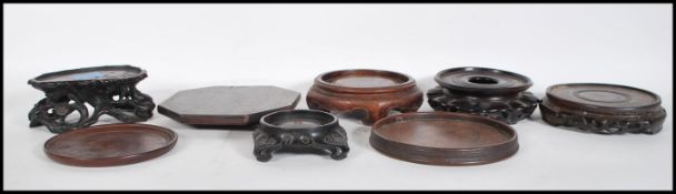 A collection of 19th century and later Chinese hardwood socle vase plinths. To include a good oval
