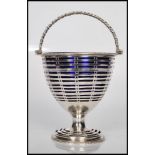 A early 19th Century Regency silver hallmarked bonbon baskets having swing turned handle atop with