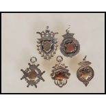 A group of five silver pocket watch albert chain fob medals, two having central armorial 9ct