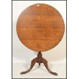 An 18th century Georgian country oak tilt top table. Raised on splayed legs with turned column