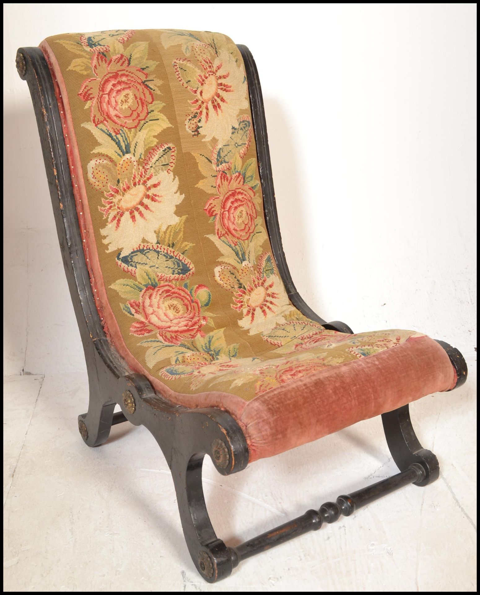 A 19th Century ebonised parcel gilt frame nursing slipper chair, button back upholstered seat pad