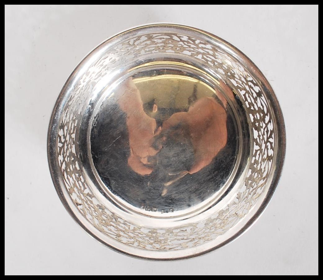 A early 20th Century silver hallmarked dish having pierced foliate decoration raised on three - Image 4 of 6