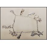 A silver charm bracelet having eleven charms including dog, violin, horse shoe, lion, bean, squirrel