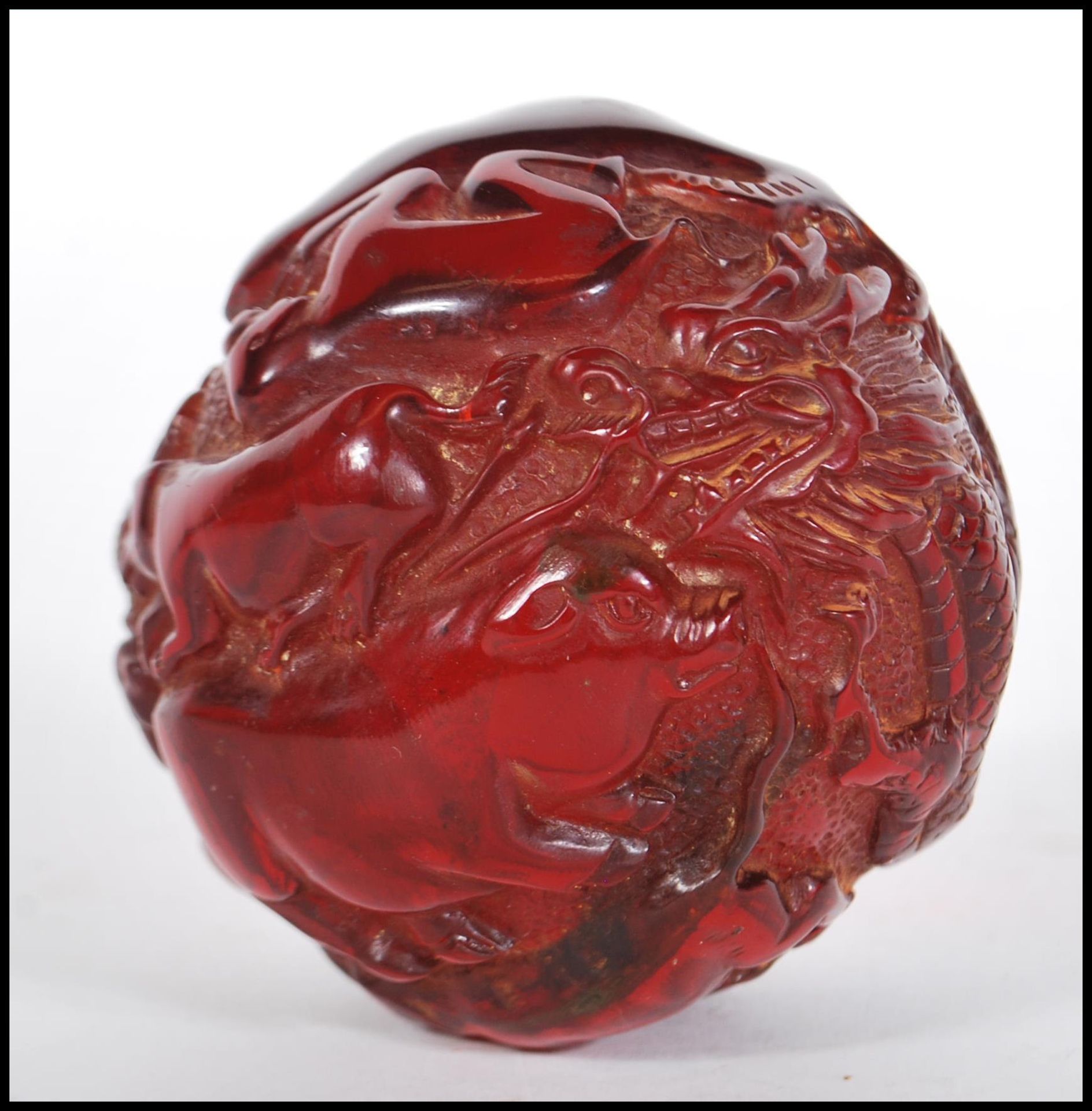 A 20th Century Chinese deep red resin sphere decorated with raised animals including a four toed - Bild 2 aus 4