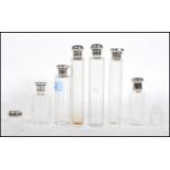 A collection of silver lidded faceted glass dressing table scent bottles to include a pair of Asprey