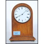 An Edwardian mahogany dome top mantel clock with enamel dial having roman numeral chapter ring and
