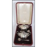 A pair of 19th Century Victorian silver hallmarked cased rococo style table salts and spoons,