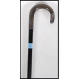 A silver hallmarked walking stick with ebonised shaft and a crook horn handle. Silver collar