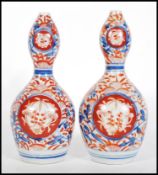 A pair of 19th century Chinese Imari pattern gourd vases, each with polychrome decoration with
