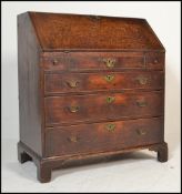 An 18th century country oak bureau. Raised on bracket feet having a chest of drawers beneath fall
