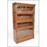 An early 20th Century oak four tier stacking Globe Wernicke bookcase having glass lift and retract