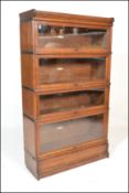 An early 20th Century oak four tier stacking Globe Wernicke bookcase having glass lift and retract