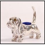 A stamped sterling silver pin cushion in the form of a blood hound with yellow and black glass eyes.