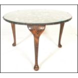 A 20th Century vintage glass topped coffee table of round form being set with an array of exotic