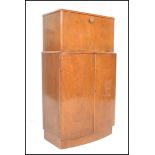 A mid century, post war Art Deco style walnut cocktail / drinks cabinet. Of bow front form raised on