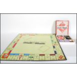 A vintage early 20th Century wartime Monopoly set in good condition, the playing pieces made from