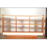 A retro 20th Century teak wood low open bookcase together with another of sectional form.