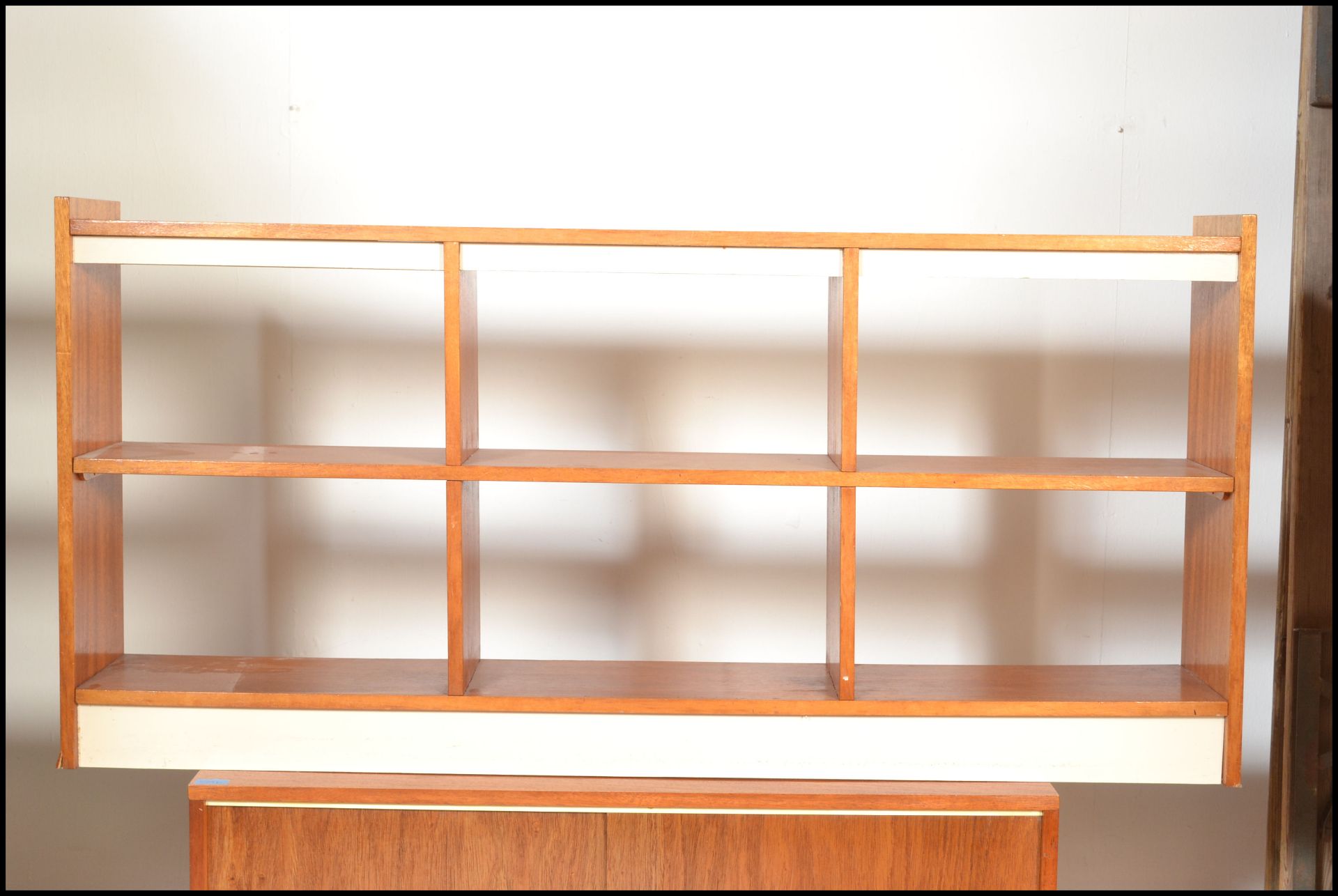 A retro 20th Century teak wood low open bookcase together with another of sectional form.