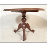 A Victorian 19th century mahogany tilt top breakfast / loo table being raised on tripod leg base