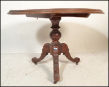 A Victorian 19th century mahogany tilt top breakfast / loo table being raised on tripod leg base