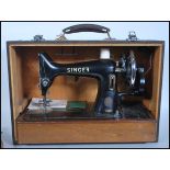 A vintage mid 20th Century cased Singer manual sewing machine set within a faux crocodile carry