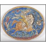 A 19th Century Persian Islamic Qajar faience pottery tile of oval form hand painted with a rider