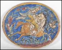 A 19th Century Persian Islamic Qajar faience pottery tile of oval form hand painted with a rider