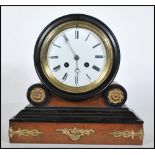 A 20th Century French style mantel clock on a plinth base with gilt scrolled detailing having a