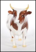 A ceramic Beswick figurine modelled as a Ayrshire bull 'CH Whitehill Mandate' no 1454B L 19 cm.