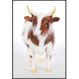 A ceramic Beswick figurine modelled as a Ayrshire bull 'CH Whitehill Mandate' no 1454B L 19 cm.