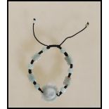 A contemporary Chinese carved jade strung bead bracelet having a large carved lotus flower with