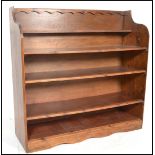 A large 20th century stained pine open window bookcase of ecclesiastical design. The central shelves