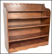 A large 20th century stained pine open window bookcase of ecclesiastical design. The central shelves