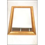 A 20th century Antique style revival gilt mirror of rectangular form with cushion frame having