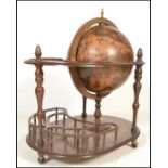 An antique style floor standing cocktail drinks cabinet in the form of a terrestrial globe with