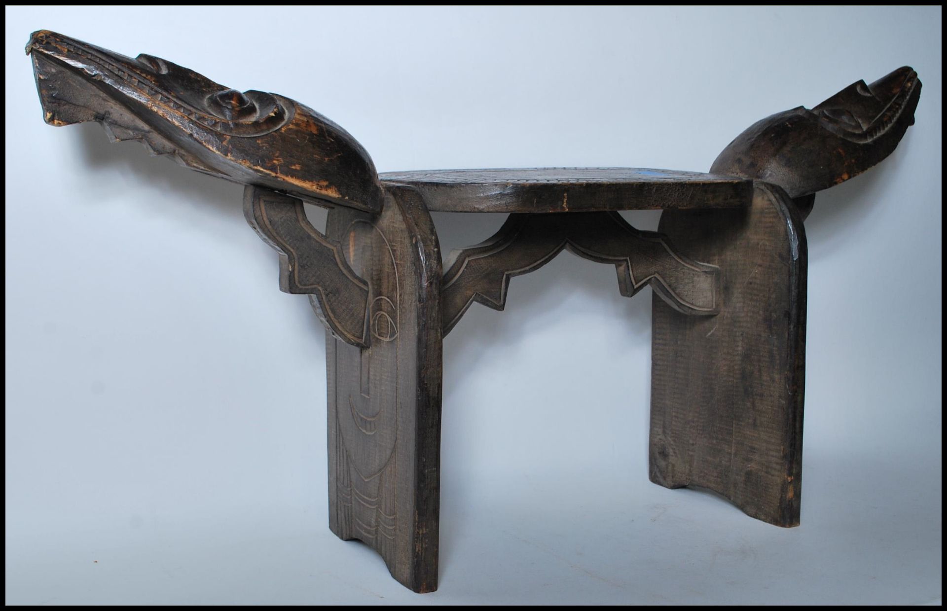 A vintage African carved tribal stool, the seat pad with chase decoration carvings flanked by carved - Bild 2 aus 4