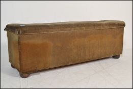 A large 19th century Victorian velour upholstered ottoman. Raised on bun feet, the wide body being