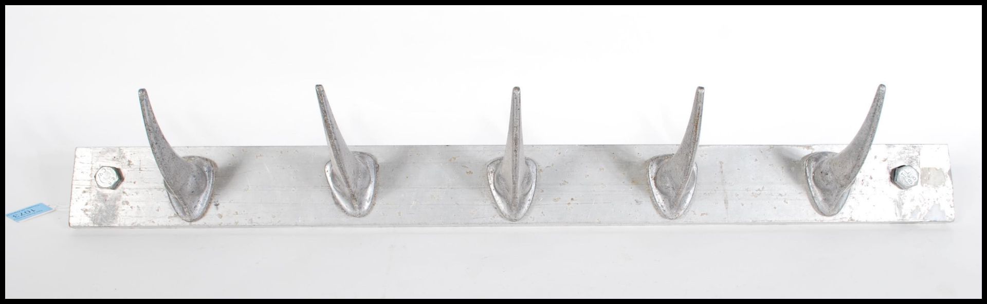 A metal 20th Century wall hanging coat rack having Rhino horn shaped hooks. Five hooks in total.