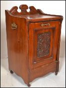 An early 20th Century Edwardian walnut pedestal coal scuttle, gallery back with full front carved