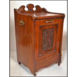 An early 20th Century Edwardian walnut pedestal coal scuttle, gallery back with full front carved